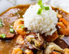 Poche's Seafood Gumbo 2lb, close-up of hearty seafood gumbo served with a scoop of rice garnished with chopped green onions.