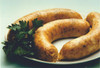 Cajun Original Hot Pork Boudin 1lb, cooked sausage on a white plate with fresh parsley garnish.