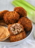 Comeaux's Pork Boudin Balls 1lb, crispy breaded pork boudin balls with one cut open showing the seasoned pork and rice filling, served with dipping sauce on a white plate.
