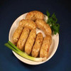 Cajun Original Shrimp Party Link 1lb, cooked shrimp sausages on a white oval plate garnished with green herbs and scallions