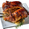 Poche's Turducken with Crawfish & Shrimp, cooked and sliced open to show the savory stuffing inside, served on a white plate with rosemary garnish.