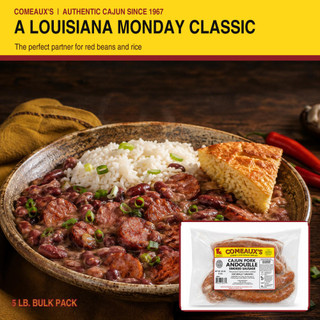Comeaux's Pork Andouille, raw smoked sausage in clear packaging with label, on a wooden table with a Cajun dish of rice, red beans, sausage, and cornbread.