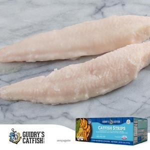 Guidrys Catfish Strips 4lb, fresh uncooked catfish fillets laid on marble surface with product packaging visible in the corner.