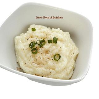 Carnival Creamy Grits with Cheese 4lb, a bowl of creamy, cheesy grits garnished with chopped green onions and black pepper.
