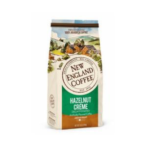 New England Coffee Hazelnut Creme Decaf Ground 10 oz, packaging featuring a scenic landscape illustration and a green label indicating hazelnut creme flavor and decaffeinated coffee.