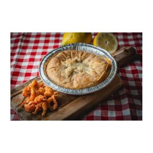 La Boucherie Crawfish Pie, 0.75 lb, served in a pie dish on a wooden board with lemon and fried crawfish on the side, on a red and white checkered tablecloth.