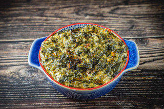 La Boucherie Creamed Spinach Side Dish 2 lb, served in a colorful ceramic bowl on a rustic wooden table.