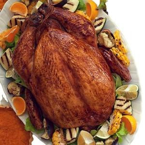 Lightly Seasoned Cajun Fried Turkey 10 lb., golden-brown fried turkey surrounded by grilled vegetables and lemon wedges.
