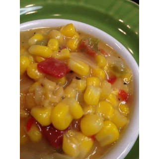 King Creole Corn Maque Choux 4lb, close-up of a bowl of creamy, colorful corn and vegetable mixture with red and green peppers in a white bowl