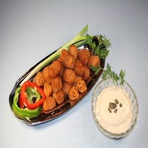 Cajun Original Shrimp Cajun Bites 12lb (312 Bites), a plate of crispy, golden-brown shrimp bites garnished with fresh vegetables, served with a dipping sauce.