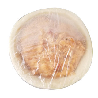 Poche's Poches Crawfish Pie, close-up of the round pie wrapped in clear plastic revealining the crawfish filling inside.