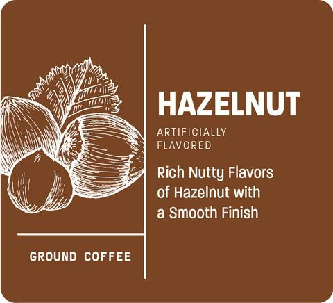 New Orleans Roast Hazelnut Ground 12oz, brown packaging label with white sketch of hazelnuts and a description of hazelnut flavor in coffee.
