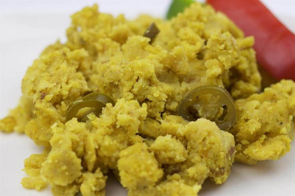 La Boucherie Jalapeno Cornbread Dressing 2 lb, close-up of yellow cornbread stuffing with jalapeño slices on a white plate.