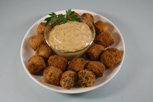 Cajun Original Pork Cajun Bites 12lb (312 bites), crispy breaded pork bites with dipping sauce garnished with parsley on a white plate.