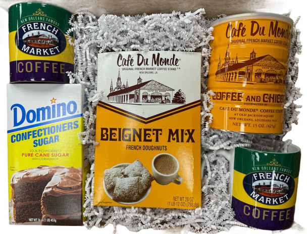 Creole Foods of Louisiana Mardi Gras Beignet Box, a gift set containing French Market coffee cups, beignet mix, confectionsers sugar, and French doughnut mix, arranged on shredded paper padding.