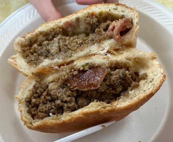 M&R Creole's Stuffed Bread 4ct, sliced stuffed bread with seasoned ground meat filling and cheese inside.