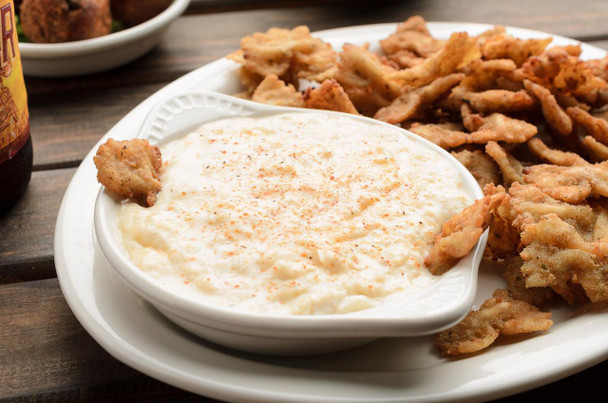 Broussard's Bayou Broussards Bayou Company Crab Dip 2.5lb, creamy crab dip served with fried calamari on a white plate.
