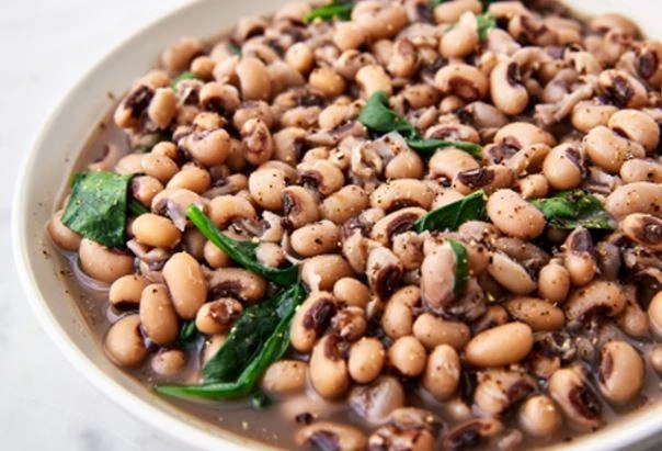 Broussard's Bayou Broussard's Blackeyed Peas and Tasso 24oz, cooked black-eyed peas with Tasso ham and green herbs served in a white bowl.