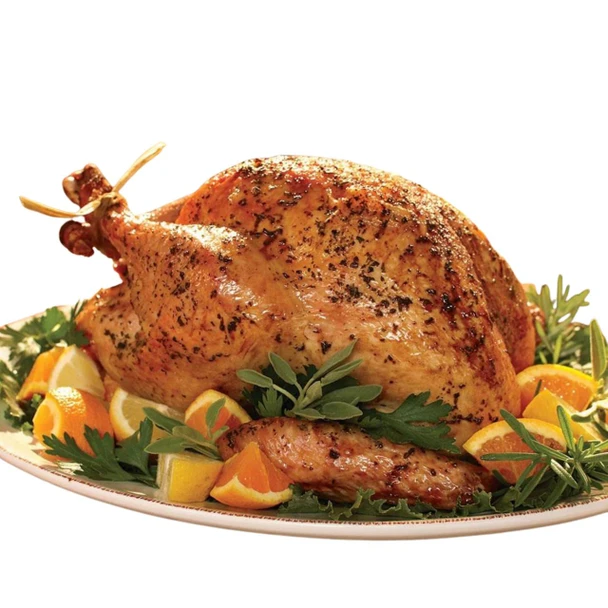 The Cajun Turkey Company Herb Roasted Turkey 10 - 12lb, image of a fully cooked, herb-seasoned roasted turkey garnished with fresh herbs and citrus slices, served on a platter.