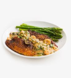 Dr Gumbo St Stevie Sauce 2.5lb, a jar of flavorful sauce with fresh green asparagus and a plate of seasoned, cooked fish topped with sauce