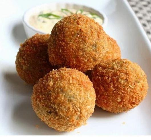 Poche's Poches Boudin Balls 12 Pack, golden-brown breaded and fried boudin balls served with a side of creamy dipping sauce.