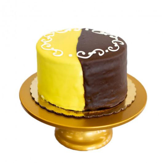 Gambino's Chocolate & Lemon Doberge Cake, delicious layered cake with half covered in yellow lemon glaze and half in rich chocolate glaze, decorated with white icing script.