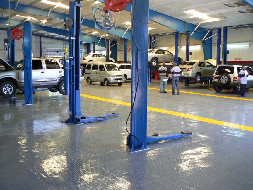Municipal automotive repair shop with interlocking floor tiles and vehicle lifts