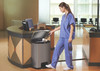 1901992 - A stainless steel Rubbermaid Slim Jim Front Step Pedal Bin situated in a waiting room and being used by a doctor in blue scrubs