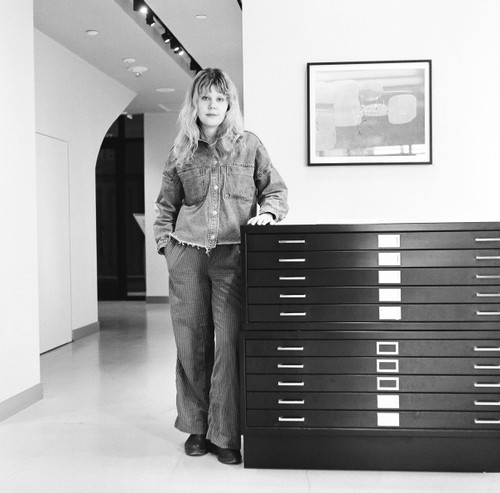 Gallery curator standing in exhibition space representing one-on-one portfolio review sessions