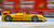 Yellow F1 car driving past red blurred background