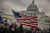 Crowd gathered with American flag in front of the U.S. Capitol capturing political tension and scale