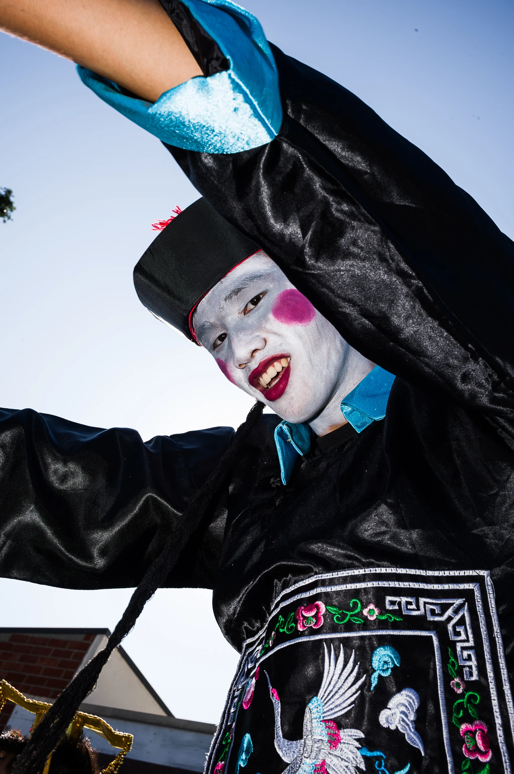 Portrait of a performer in a black and blue costume against a clear sky