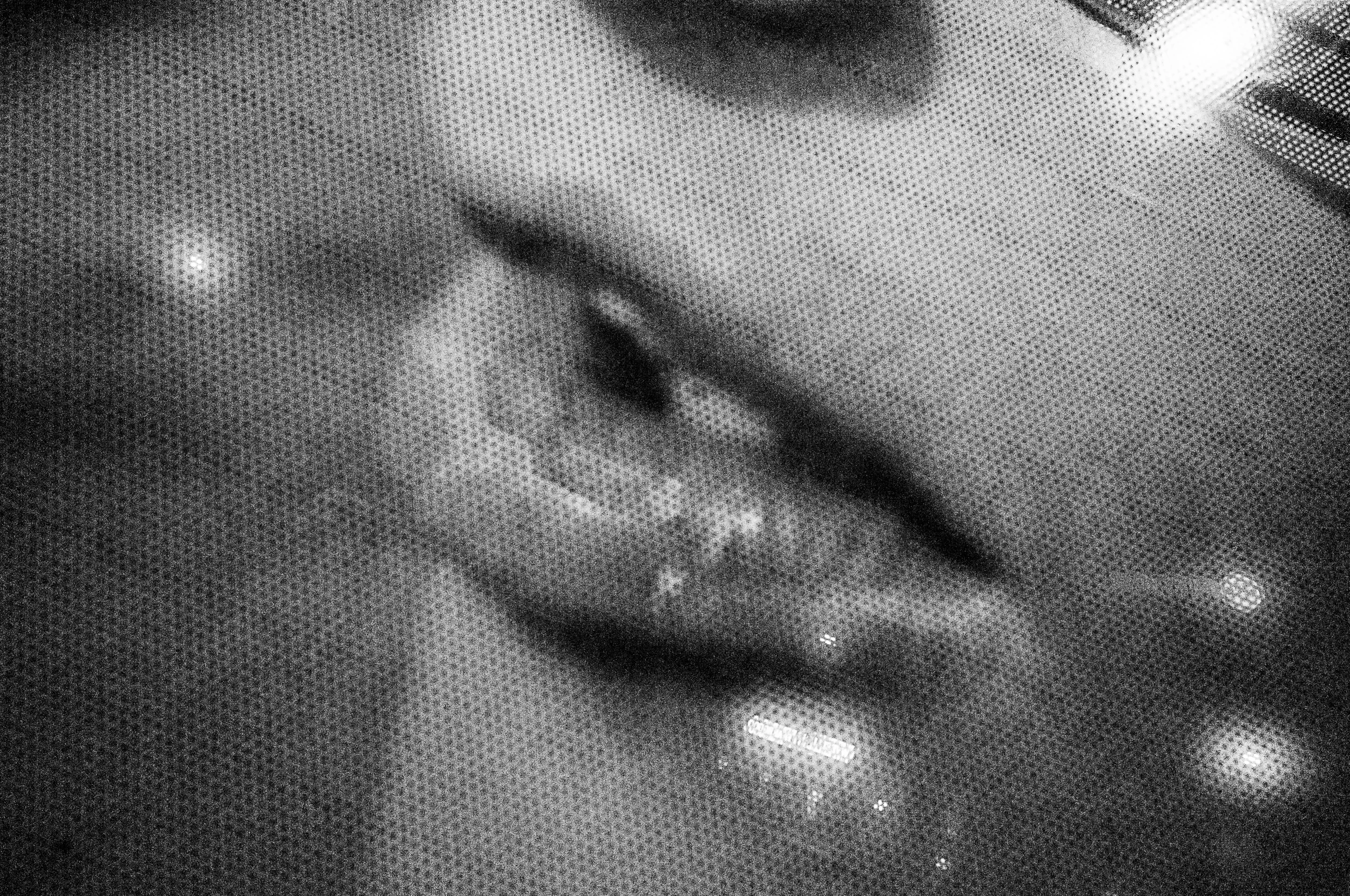 Grainy black-and-white close-up photograph of a face