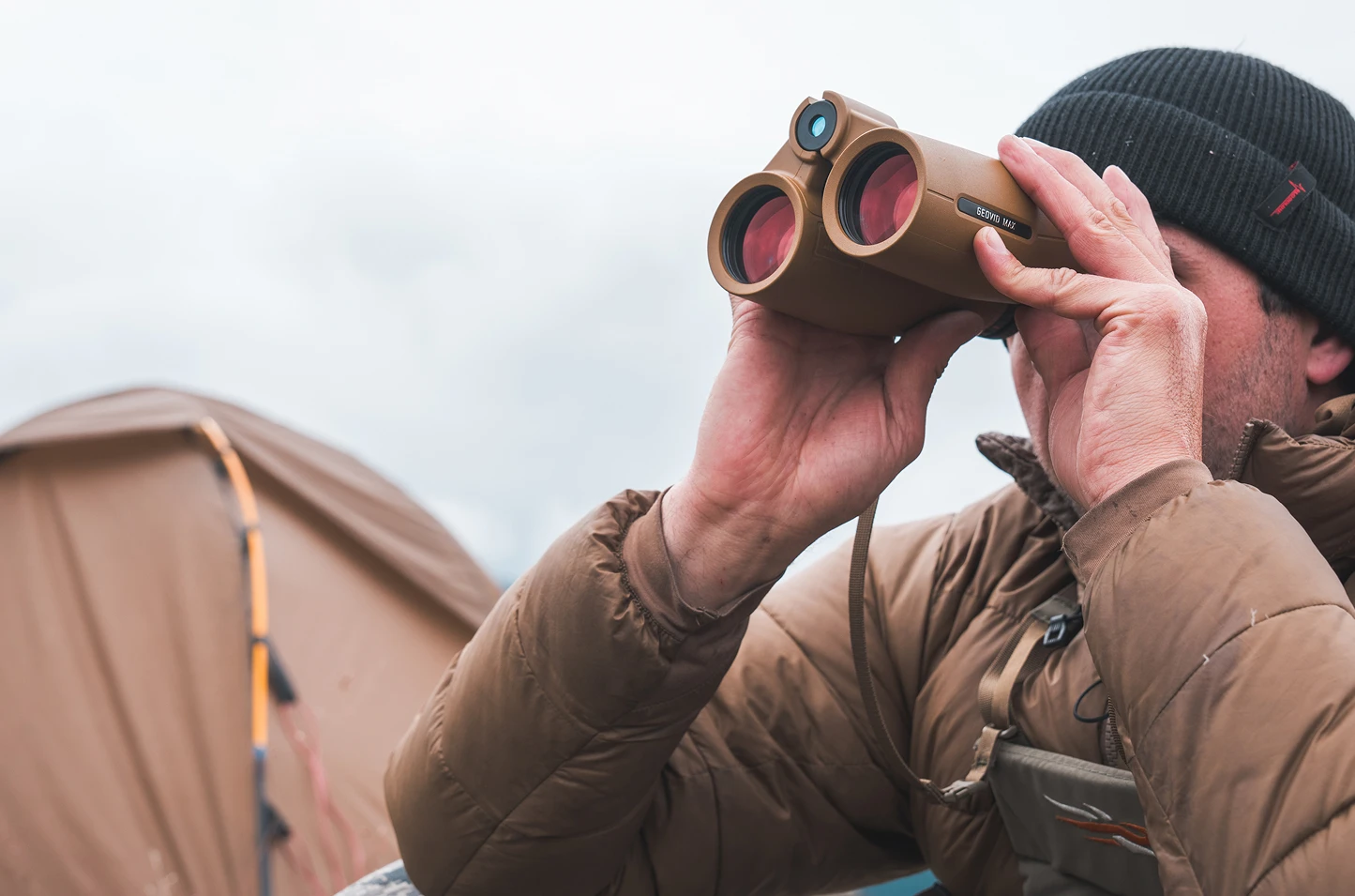 Man holding and looking through a high-performance Leica Geovid 10x42