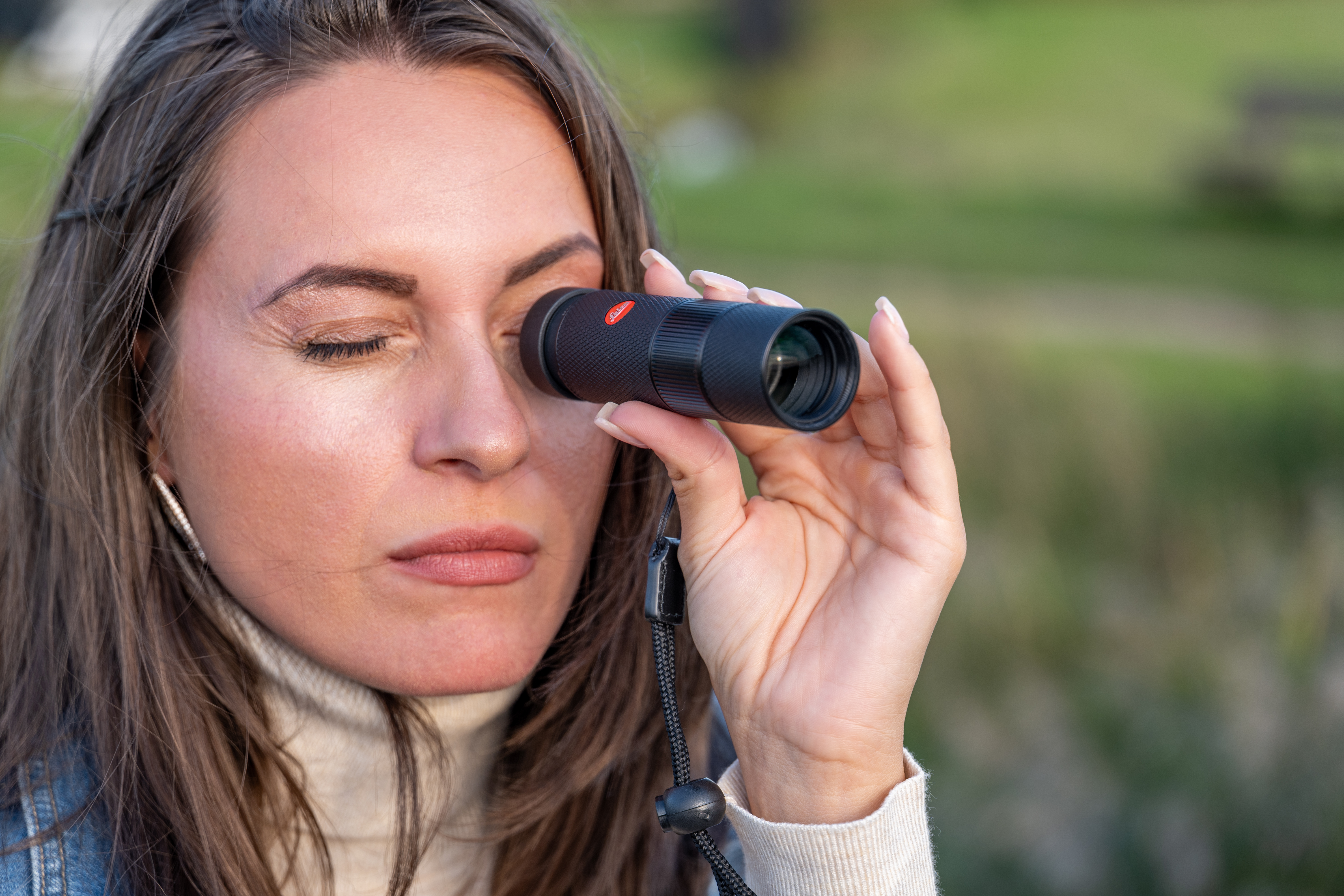 Woman looking through Leica Monovid 8x25 Black Leather