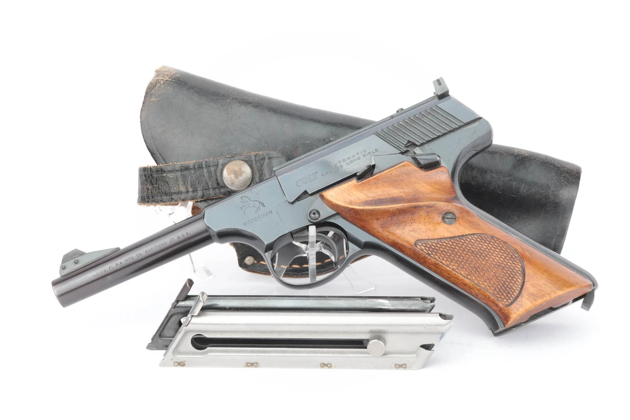 1957 Colt Woodsman third series .22 LR pistol - shown with two magazines and black leather holster