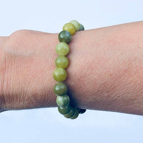 Green Jade 8mm Bead Bracelet worn on arm with pale blue background