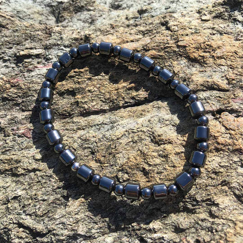 Magnetite 6mm Barrel Round Bead Bracelet resting on a rock ledge