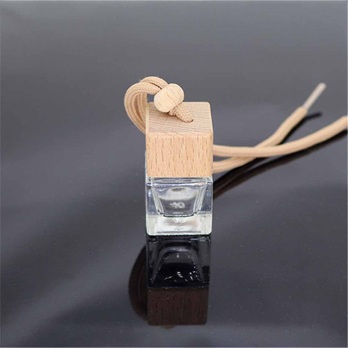 Glass pendant with wood lid and cord on grey background