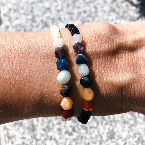 Chakra Star Cut Black and Cream Braided Cord Bracelets worn on wrist