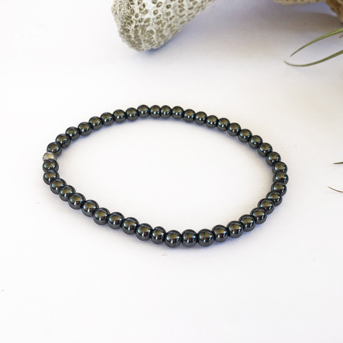 Magnetite Magnetic 4mm bead anklet on white background with coral behind