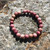 Pink Rhodonite 8mm bead stretch bracelet with rock ledge behind