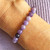 Lilac Purple Lepidolite with Mica 6mm bead bracelet on wrist with a lilac jumper in background.