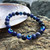 Evil Eye and Sodalite 8mm Bead Bracelet resting on a shell and rock ledge