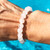 Quartz 8mm Bead Bracelet on hand with water behind
