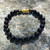 Pixiu Om Black Obsidian 8mm Bead Bracelet with rock ledge behind