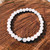 White Jade 8mm bead bracelet resting on a timber board