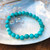 Aqua Blue Magnesite 8mm Faceted Bead Bracelet with large shell behind