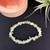 Prehnite Premium Chip Stretch Bracelet on black background with Salt Lamp and Air Plant behind