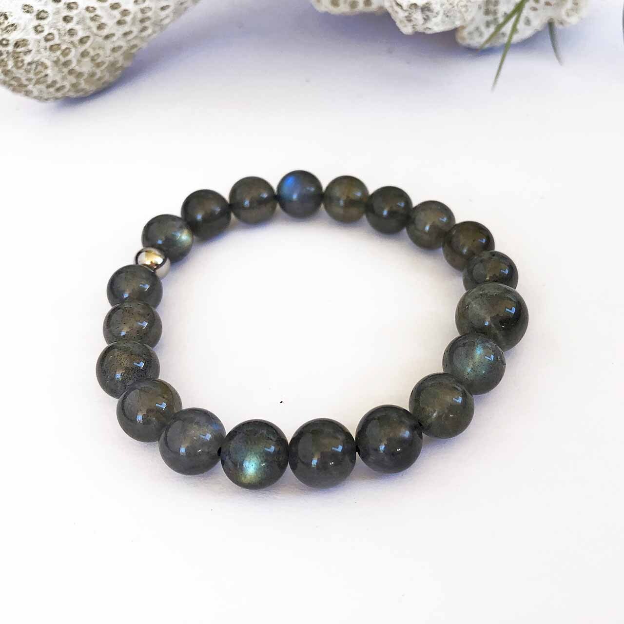 magnetite bead bracelets resting on shell with rocks behind